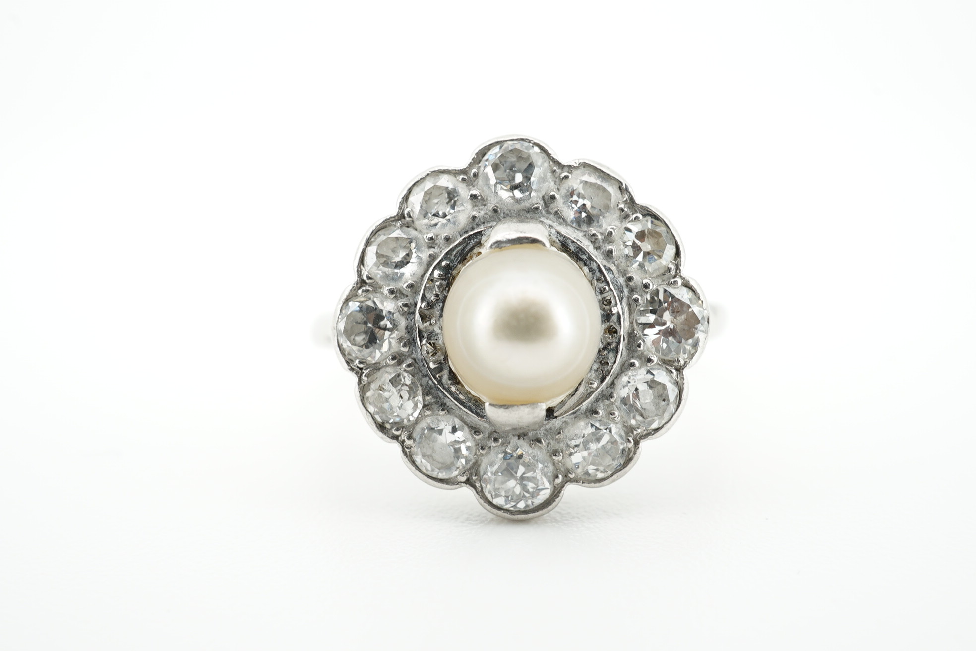 An 18ct and plat. cultured pearl and diamond set circular cluster ring, size O, gross weight 3.5 grams. Condition - fair